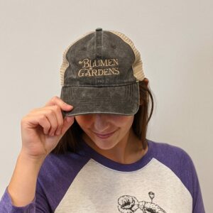 women modeling baseball cap with Blumen Gardens logo